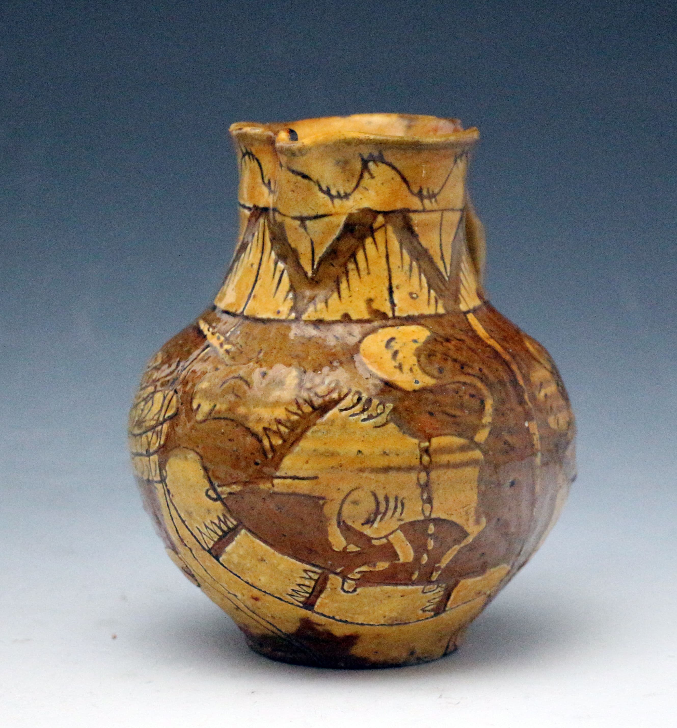 Devon pottery slipware jug with scraffito decoration of a bird and unicorn with inscription and