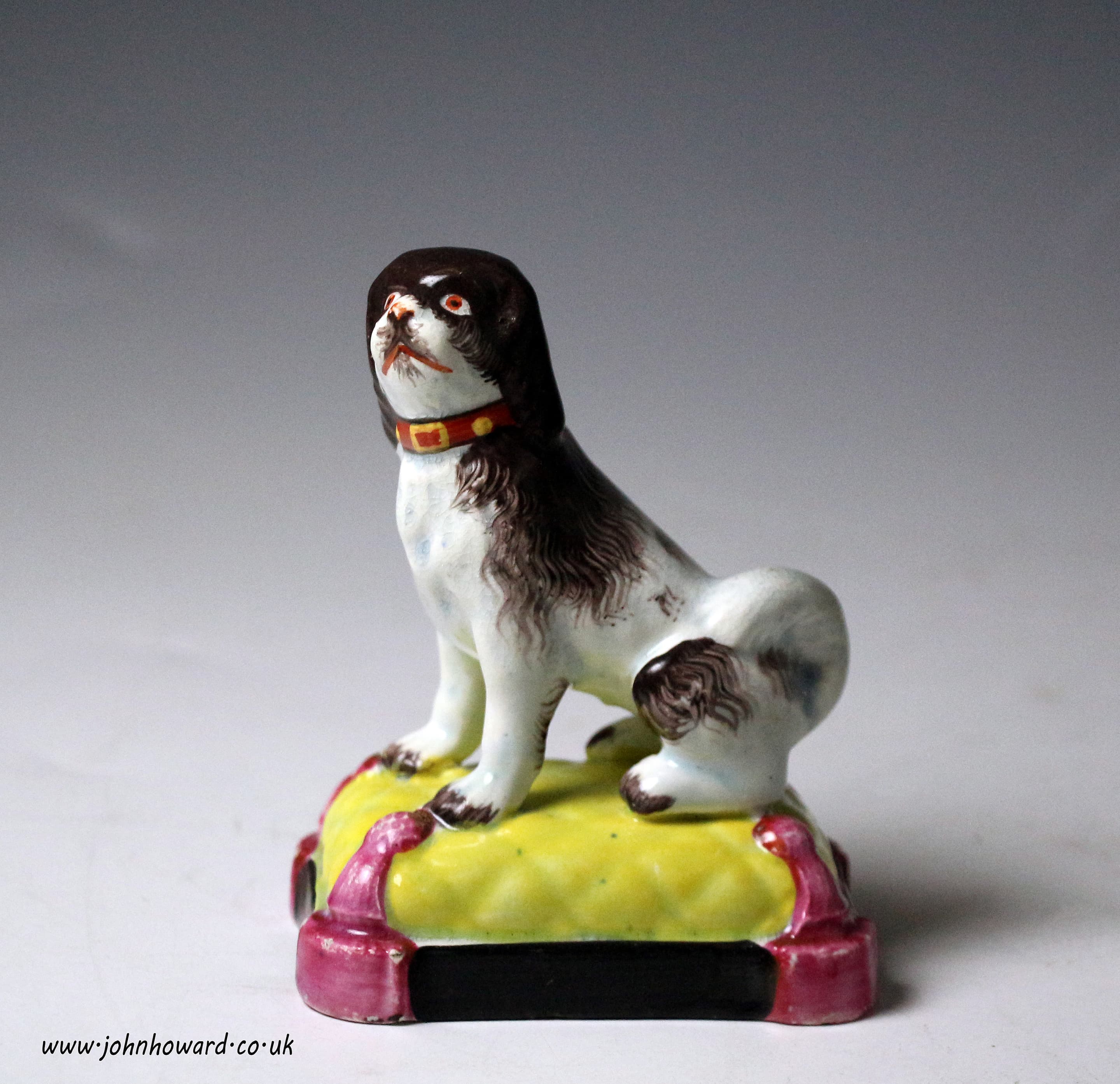 Staffordshire pottery pearlware figure of a dog seated on cushion base ...