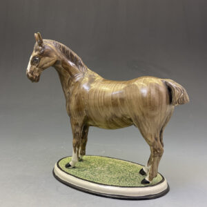 Pottery figure of a horse standing on an oval shaped base made England circa 1800